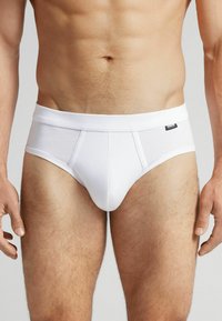 Weiße Baumwollslips mit einem breiten elastischen Taillenbund, einem taillierten Design und einer glatten Textur. Verfügt über dezente Nahtdetails und ein Markenlabel.