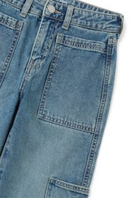 Jeans de mezclilla azul con grandes bolsillos laterales cuadrados, trabillas para cinturón y un cierre de botón metálico en la cinturilla.