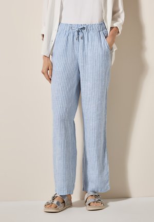 Lichtblauwe gestreepte broek met een elastische tailleband en trekkoord, voorzien van zijzakken en een relaxte pasvorm, gecombineerd met casual sandalen.