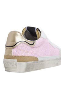 Zapatillas de purpurina rosa con parte superior texturizada, detalles metálicos dorados en el talón y suela de goma gris. Presenta el año "1973" en el costado.