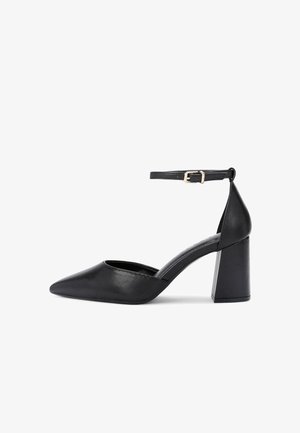 Chaussure à talon haut pour femme en cuir noir avec bout pointu, bride de cheville avec boucle dorée et talon bloc épais.