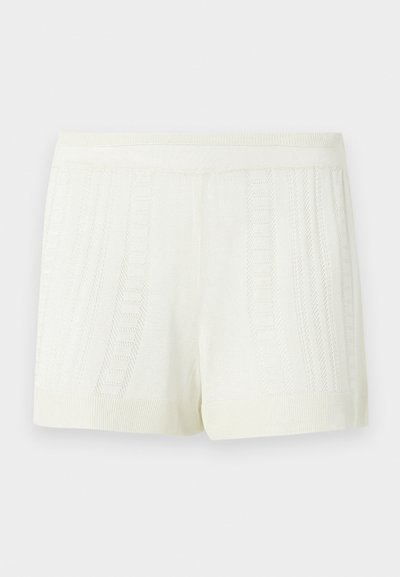 Πλεκτό σορτς σε κρεμ χρώμα με κάθετα υφασμάτινα μοτίβα και φαρδύ ελαστικό ζωνάρι σε απλό φόντο.