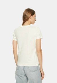Helles, kurzärmliges T-Shirt aus weicher Baumwolle mit klassischem Rundhalsausschnitt und gerader Silhouette mit seitlichen Schlitzen.