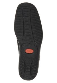 Suela de zapato negra con superficie de goma texturizada, que presenta un botón rojo central con el nombre de la marca "ara" y patrones de banda de rodadura distintos para mejor agarre.