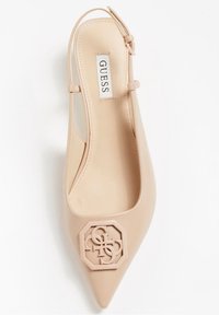 Flats beiges à bout pointu avec un ornement en logo découpé octogonal et une fine bride de cheville ajustable.