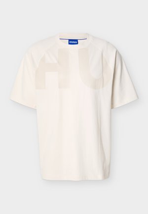 T-shirt en coton blanc à coupe décontractée, doté d'un grand graphisme translucide "HU" sur le devant et de manches raglan.