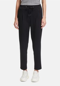 Pantalons de jogging noirs fuselés avec une taille à cordon de serrage, des plis à l'avant et des poches latérales, confectionnés dans un tissu doux et léger.
