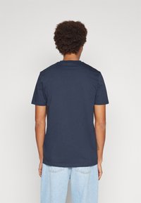 Mörkblå bomullströja med korta ärmar, rund halsringning och avslappnad passform. Enkelt design utan synliga logotyper eller mönster.