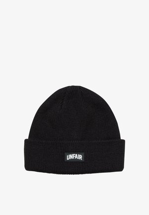 Bonnet en tricot noir avec un revers replié. Présente un motif texturé et une étiquette rectangulaire avec le mot "UNFAIR" en lettres blanches.