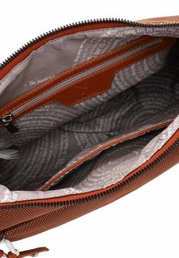 Bruine stoffen crossbodytas met ritssluiting, voorzien van een grijze binnenvoering met patroon en een extra ritssluitingvak aan de binnenkant.