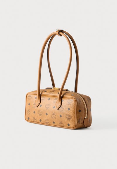 Καφέ δερμάτινη τσάντα χειρός με δύο λαβές στο πάνω μέρος, ορθογώνιο σχήμα, χρυστό φερμουάρ και ανάγλυφο μοτίβο λογοτύπου. Διακοσμημένη με διαμαντένια στοιχεία.