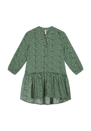 Fille portant une robe boutonnée verte à motif d'étoiles, manches trois-quarts, des baskets blanches montantes et des chaussettes blanches avec des rayures bleues.