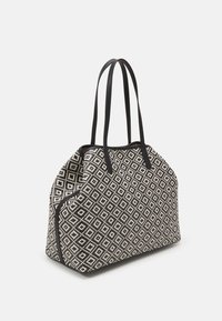 Czarna i biała torba typu tote w geometryczny wzór diamentowy, wykonana z teksturowanej tkaniny, z dwoma czarnymi uchwytami i detalami w postaci zamka.