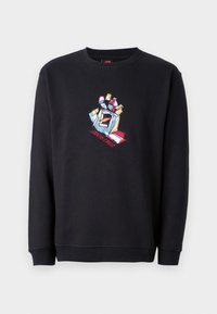 Felpa nera in cotone, con una grafica colorata di un pugno alzato e il testo "Santa Cruz" in colori vivaci. Taglio classico con polsini a costine.