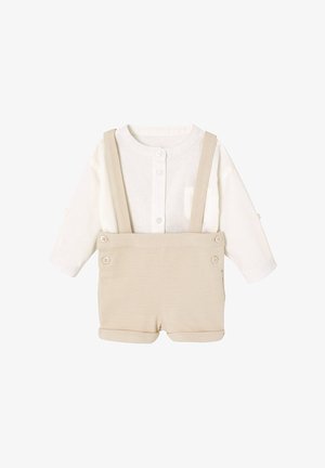 Weißes Babyoberteil mit langen Ärmeln und Knöpfen vorne, kombiniert mit beigen Hosenträger-Shorts mit Knopfdetails und hochgekrempelten Säumen.