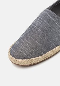Šedé lněné espadrilky s juteovým vláknem na podešvi, s kulatou špičkou a texturovaným vzorem látky.