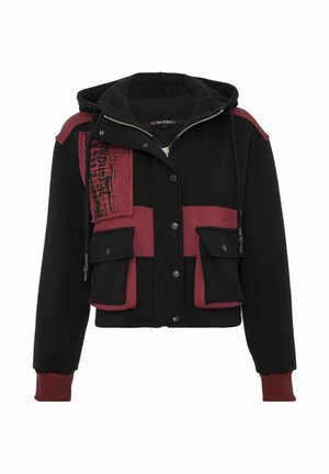 Afgekorte jas met zwart en bordeauxrood stof, knoopsluiting aan de voorkant, dubbele borstzakken en een getextureerd grafisch detail aan de zijkant.