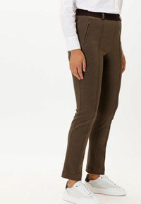 Bruna texturerade byxor med slim fit, med midjeband och en dragkedjeficka, i kombination med vita sneakers.