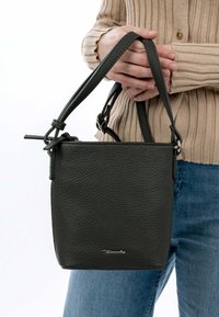 Dunkelgrüne Lederhandtasche mit strukturierter Oberfläche, rechteckiger Form und verstellbarem Tragegurt. Mit silberner Hardware und Logodetails.