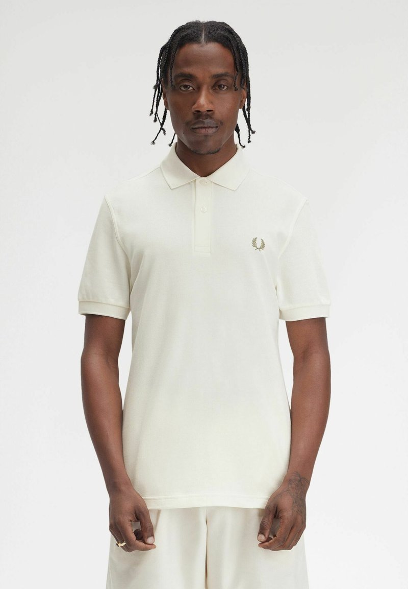 Witte polo-shirt met kraag, korte mouwen en een klein geborduurd logo op de linkerkant van de borst. Gemaakt van gestructureerde stof.