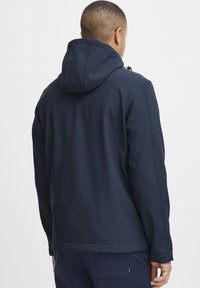 Marineblå hettegenser med snøring, glatt tekstur og broderte detaljer. Har en avslappet passform og en mid-length cut.
