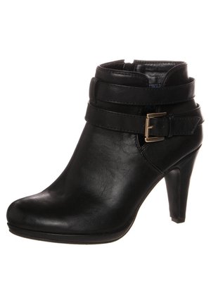 Bottine en cuir noir avec bout pointu, talon de 7,5 cm, deux sangles enroulées et une boucle latérale dorée.