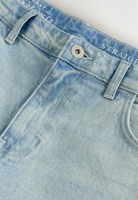 Jeans din denim de culoare albastru deschis, cu croială dreaptă, având închidere cu nasture în față, bucle pentru curea și o textură ușor decolorată.