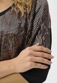 Sequin top featuring a black base with iridescent circular sequins in shades of rose gold and silver, rounded neckline, and short sleeves.