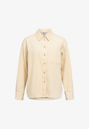 Ilgas rankovėmis, su sagomis marškiniai iš šviesiai smėlio spalvos korduro bio audinio, su apykakle, vienu krūtinės kišeniu ir gofruota tekstūra. Mediniai sagų akcentai.