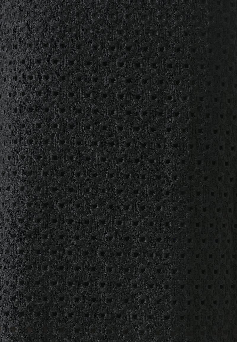 Tissu noir présentant un motif texturé de petits carrés et cercles découpés, offrant un design aéré et complexe.