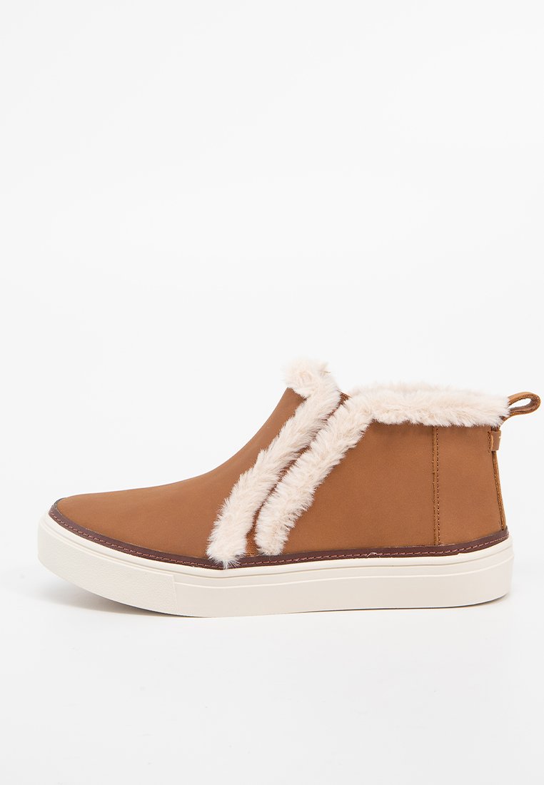 Bottines marron avec bordure en fausse fourrure blanche, fermeture éclair sur le côté et semelle en caoutchouc blanche, conçues pour un usage hivernal décontracté.
