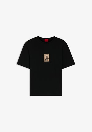 T-shirt noir à manches courtes avec une petite écusson beige sur la poitrine représentant un serpent enroulé et le texte "HUGO 1993".