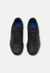 Zapatillas deportivas negras con suelas de goma texturizada, parte superior de malla y acentos interiores azules. Presentan una puntera reforzada y cordones estándar.