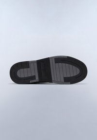 Suola di scarpa in gomma nera con scanalature orizzontali, dotata di un tallone arrotondato e bordi rigati, che mostra un centro liscio con un'impronta del logo.