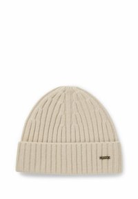 Cremefarvet strikket beanie med ribbet tekstur, der har en foldet kant og et lille metallisk accentmærke på siden.