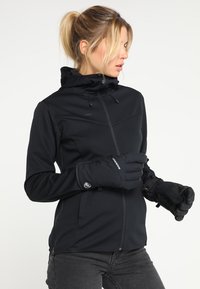 Svart zip-up jacka med huva, med en slät textur och figurnära design. Matchas med svarta handskar, detaljer inkluderar elastiska cuffar och logotyp-accenter.