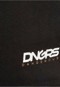 Čierna tkanina s ryhovanou textúrou, na ktorej je biele a zlaté logo s nápisom "DNGRS DANGEROUS." Logo je výrazne zobrazené na materiáli.