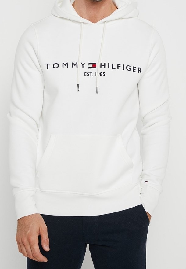 Bílá mikina s kapucí vyrobená z měkké látky. Má přední kapsu, šňůrky na stažení a černé potiskové logo s červeným a modrým akcentem.