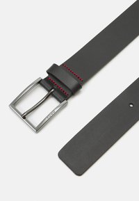 Curea din piele neagră cu cataramă din metal argintiu, având cusături roșii. Curea este plată, cu o textură netedă și un orificiu circular pentru ajustare.