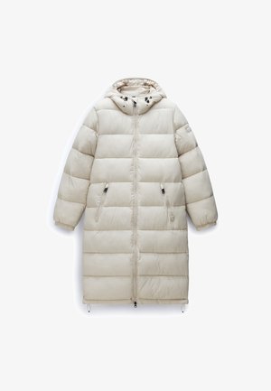 Puffiger beiger knielanger Mantel mit Kapuze, vertikaler Steppung, Frontreißverschluss und Seitentaschen, aus einem glatten, glänzenden Material gefertigt.