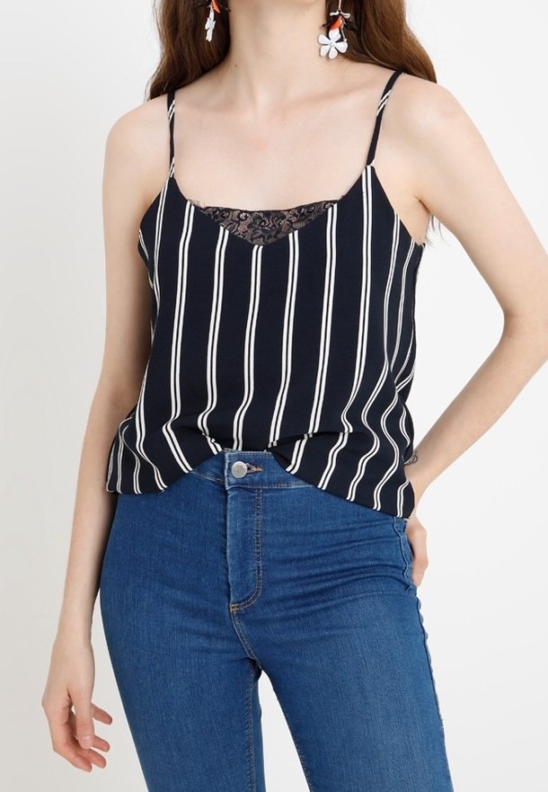 Haut sans manches bleu marine à rayures verticales blanches, bordure en dentelle au niveau du col, coupe décontractée, associé à un jean en denim bleu.