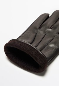 Schwarzer Lederhandschuh mit einem gerippten, dunkelbraunen Strickbündchen; verfügt über auffällige Nähte und ein angepasstes Design für Wärme und Komfort.