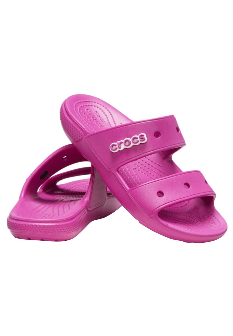 Rosa gummisandaler med dubbla remmar och ventileringshål, med en texturerad innersula och en framträdande "CROCS"-logotyp på sidan.