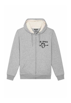 Grijze hoodie met een pluizige voering, rits aan de voorkant en twee voorkruiszakken. Heeft een bedrukte print met de tekst "Mi Amor" en een hart.