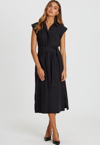 Mustat midi-mekko, jossa on hihattomat hihat, edessä napitus, vyötärön nauha ja sivuaukkote yksityiskohdat, valmistettu sileästä kankaasta.