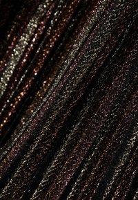 Tissu tricoté métallique en noir, avec des fils entrelacés en bronze, or et violet. Texturé avec un motif côtelé. Fini chatoyant.