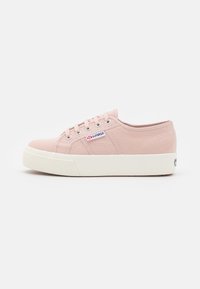 Sneaker in tela rosa chiaro con punta rotonda, suola in gomma bianca e chiusura con lacci a sei occhielli. Presenta una patch con logo sul lato e tessuto texturizzato.