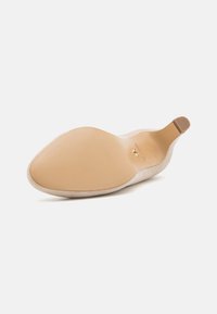 Beige semsket ballerinasko med en glatt, avrundet tå og myk innvendig. Har en tan såle og en subtil logo detalj innvendig.