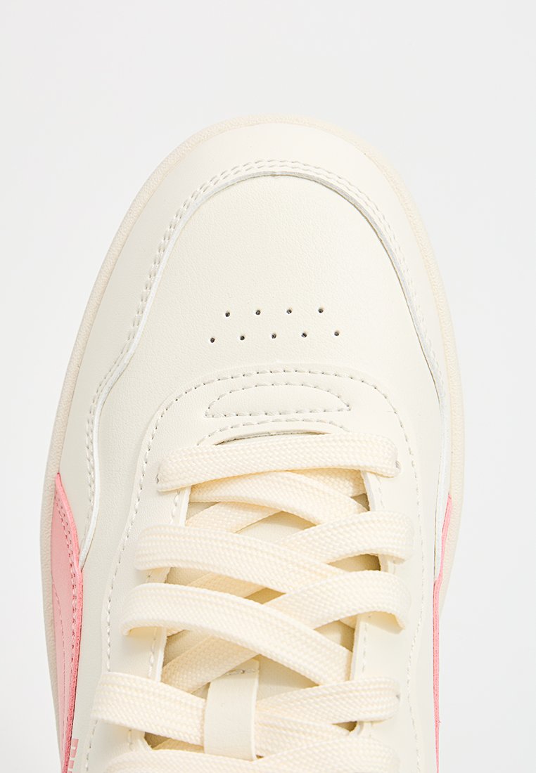 Beige Leder-Sneaker mit einem rosa Seitenteil, runder Zehenform und perforierten Details. Die Schnürsenkel sind flach und gewebt.