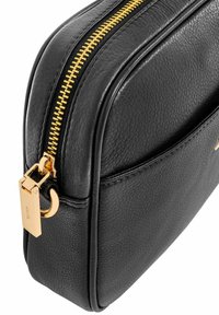 Czarna skórzana torba o teksturowanym wykończeniu, z złotym zamkiem błyskawicznym i okuciem. Projekt ma prostokątny kształt z zaokrąglonymi krawędziami i przednią kieszenią.